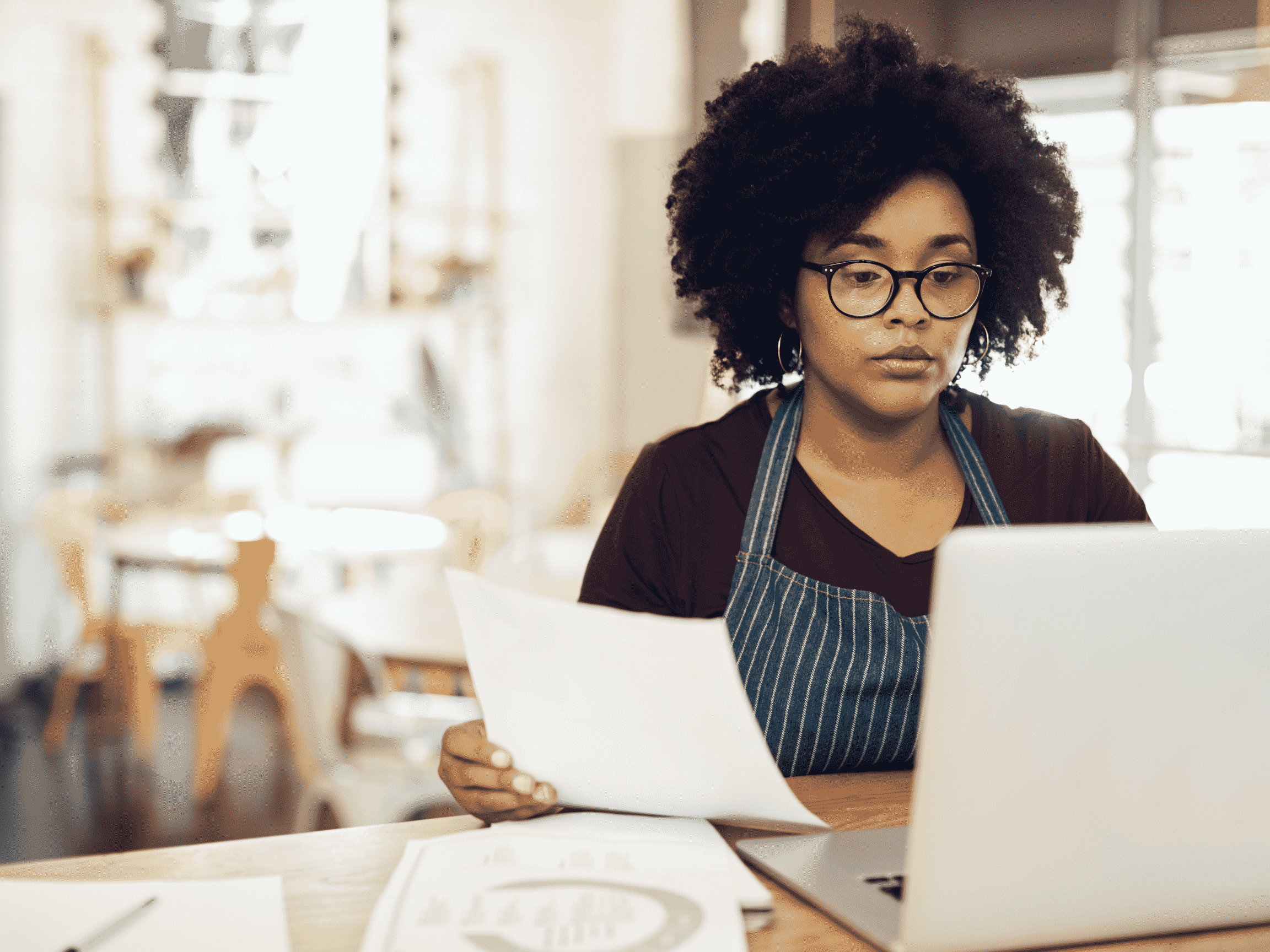 Restaurant owner processing Restaurant Payroll Canada on a laptop